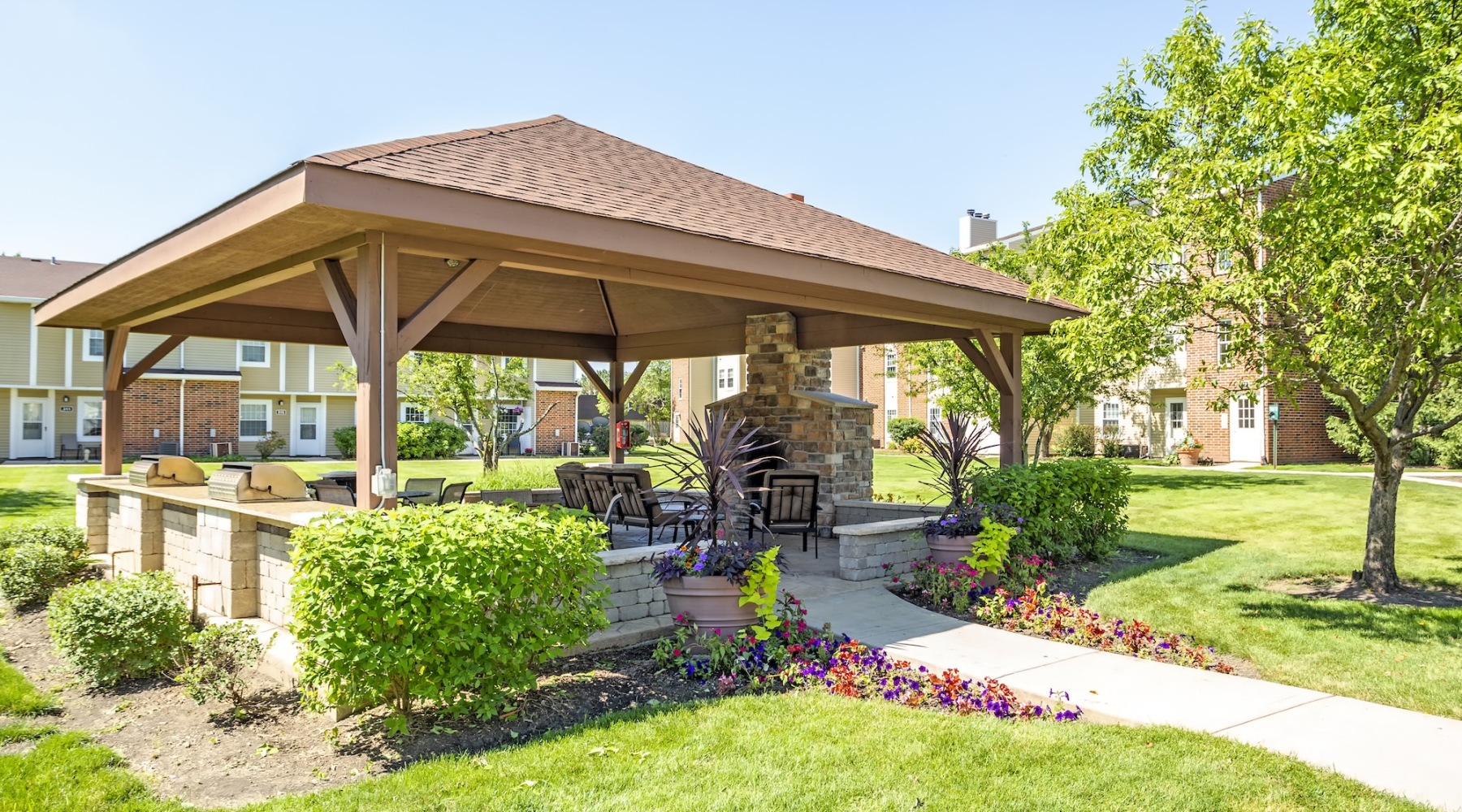 an outdoor covered grilling and lounge area